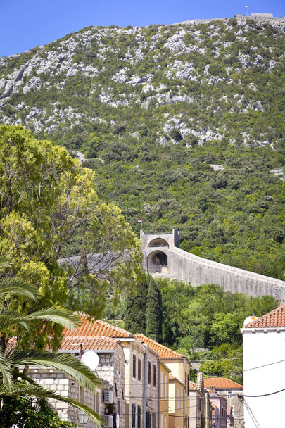 Widok na małą wioskę Ston i mury. Mury miejskie to seria murów obronnych, pierwotnie o długości ponad 7 kilometrów, otoczonych i chronionych miastem Ston, w Chorwacji. - Zdjęcie, obraz