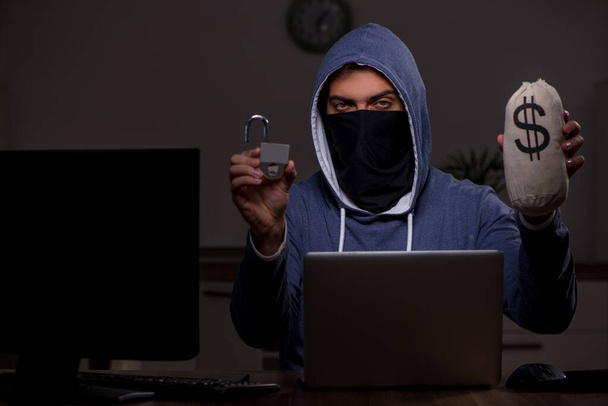 Чоловік хакер зламує брандмауер безпеки пізно в офісі
 - Фото, зображення