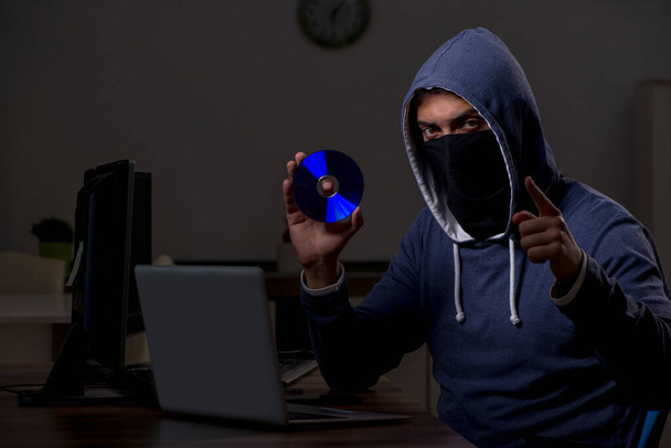 Male hacker hacking security firewall late in office - Photo, Image