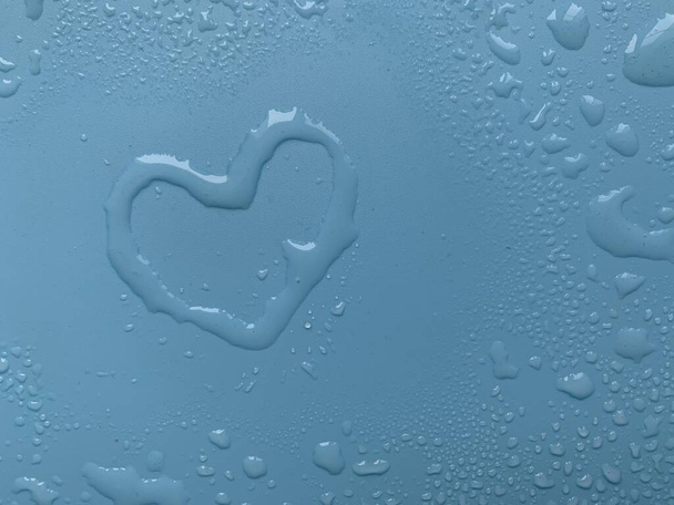 Water in heart shape on blue background - Photo, Image