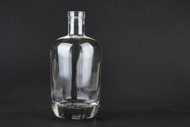 Empty spirit bottle on a black background - Foto, Bild