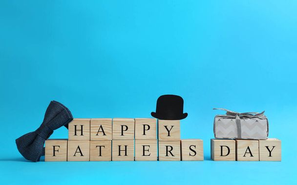 Wooden cubes with phrase HAPPY FATHER'S DAY on light blue background - Фото, зображення