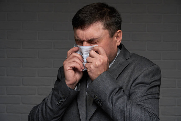 感染した男性はくしゃみや咳をし、病気の症状を持っています – 医療や医療の概念 - 写真・画像