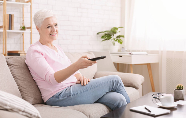 Calma donna anziana guardando la tv a casa
 - Foto, immagini