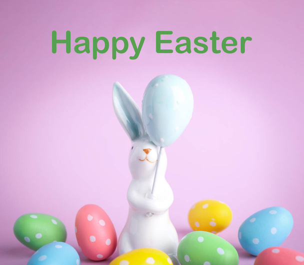Easter bunny figure and eggs on pink background - Valokuva, kuva