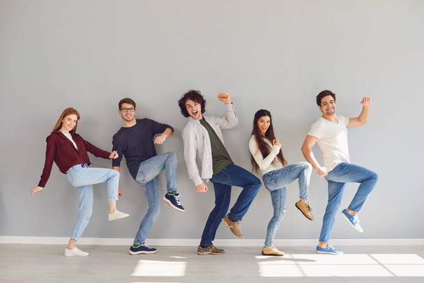 Group of young people in casual clothes smiling while gray background. - Foto, Bild