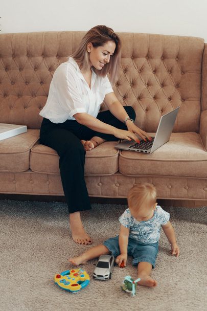 Hermosa mujer de negocios trabajando en casa. Multi-tarea, freelance y concepto de maternidad. Carrera de madre trabajadora
 - Foto, imagen