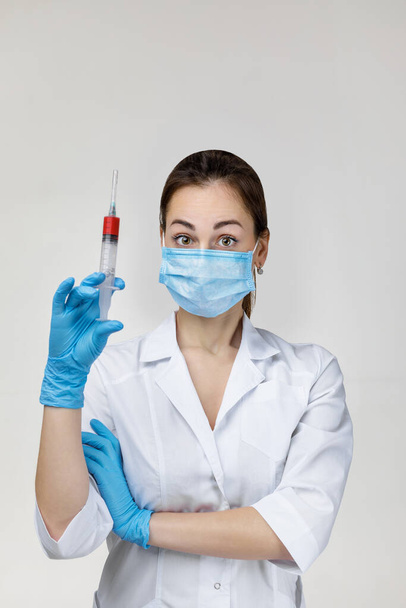 woman doctor in mask and rubber gloves holding syringe - Фото, зображення