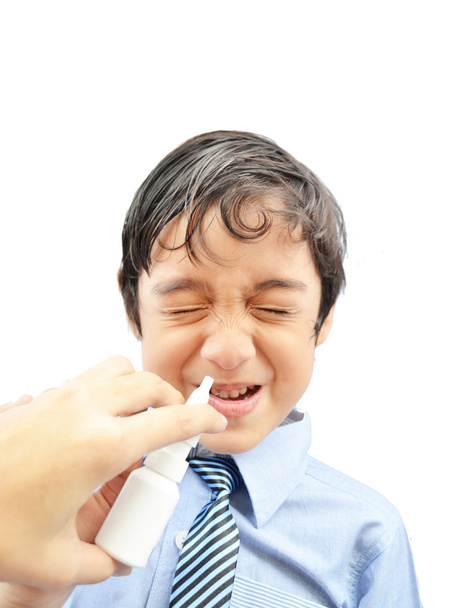 Mani che danno a un ragazzo una dose di spray nasale
 - Foto, immagini