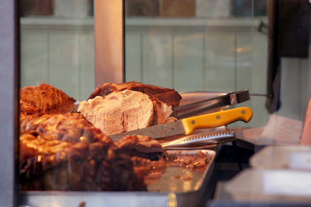 Knives and cu meat on te counter of a hot sandwich carvery business. UK. - Photo, Image