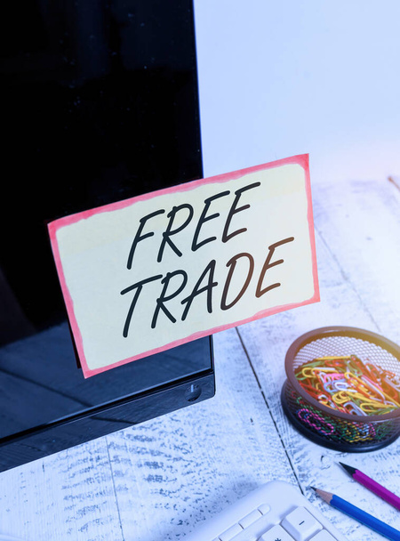 Eine Notiz, die den Freihandel zeigt. Geschäftsfoto, das den internationalen Handel ohne Zölle seinem natürlichen Verlauf überlässt Notizpapier, das auf schwarzem Computerbildschirm in der Nähe von Tastatur und Schreibtisch geklebt ist. - Foto, Bild