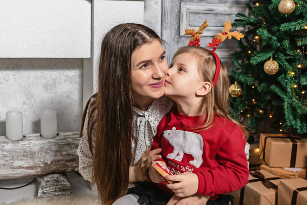 petite fille embrasser sa mère à Noël photo
 - Photo, image