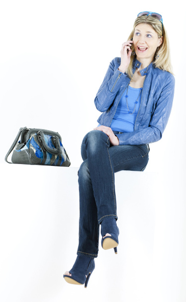 Femme assise avec téléphone portable et sac à main
 - Photo, image