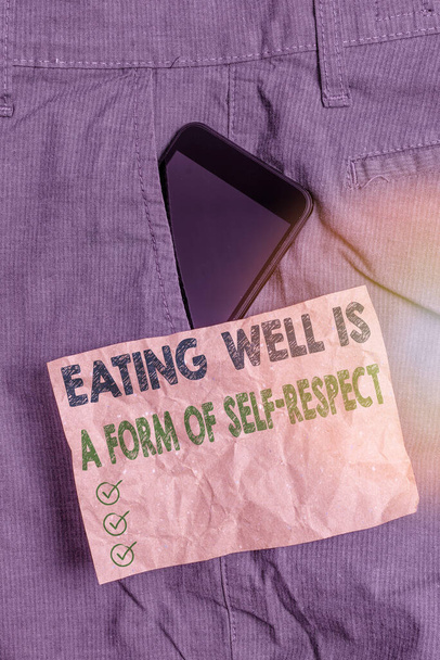 Schrijfbriefje met goed eten is een vorm van zelfrespect. Zakelijke foto presentatie van een offerte van het bevorderen van een gezonde levensstijl Smartphone apparaat in broek voor pocket note papier. - Foto, afbeelding