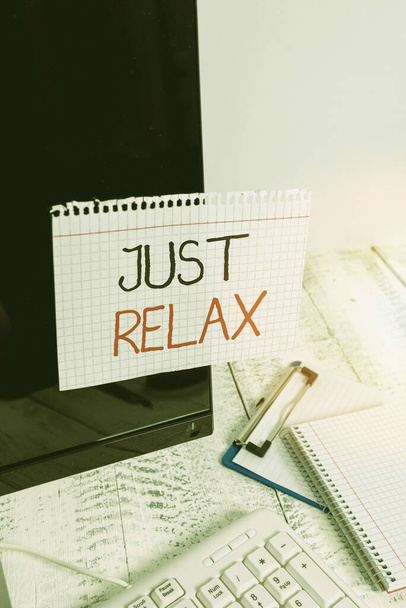 Schreiben Notiz zeigt Just Relax. Business-Foto präsentiert, um sich auszuruhen oder etwas zu tun, das Spaß macht und stressfrei Notizpapier auf schwarzen Computerbildschirm in der Nähe von Tastatur und stationär geklebt. - Foto, Bild