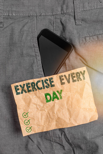 Piszę notatkę z ćwiczeniami każdego dnia. Biznes zdjęcie prezentacja przenieść ciało energicznie w celu uzyskania dopasowania i zdrowego urządzenia Smartphone wewnątrz spodni przedni papier kieszonkowy. - Zdjęcie, obraz