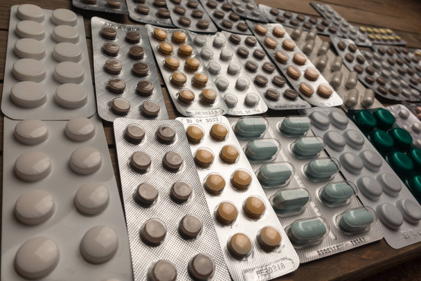 Closeup shot of different pills on table with tablets , pharmaceutical industry concept - Photo, Image