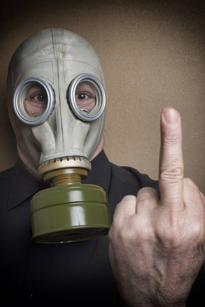 άντρας που φοράει μάσκα αερίων με το μεσαίο του δάχτυλο σηκωμένο - Φωτογραφία, εικόνα