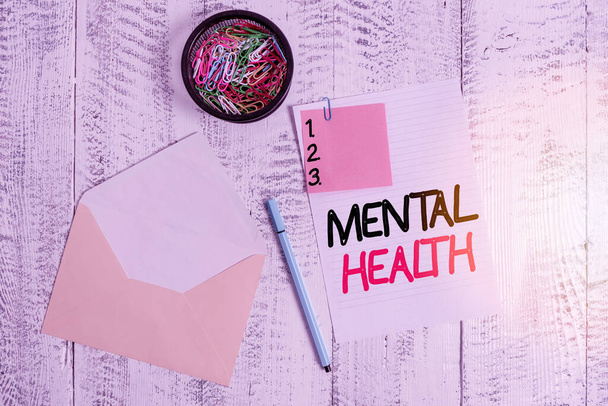 Word writing text Mental Health. Business concept for demonstratings condition regard to their psychological well being Envelope sheet paper sticky note ballpoint clips holder wooden background. - Photo, Image