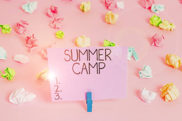 Χειρόγραφο κείμενο που γράφει Summer Camp. Έννοια σημαίνει εποπτευόμενο πρόγραμμα για παιδιά που διεξάγεται κατά τη διάρκεια του καλοκαιριού Έγχρωμα τσαλακωμένα χαρτιά κενό υπενθύμιση ροζ πάτωμα φόντο μανταλάκι. - Φωτογραφία, εικόνα