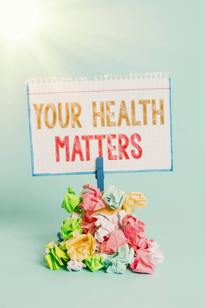 Handwriting text writing Your Health Matters. Concept meaning good health is most important among other things Reminder pile colored crumpled paper clothespin reminder blue background. - Photo, Image