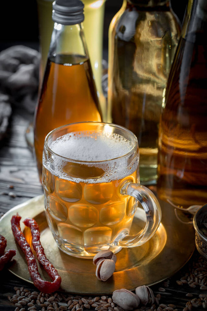 Light beer in a glass on a table in composition with accessories on an old background - Fotografie, Obrázek