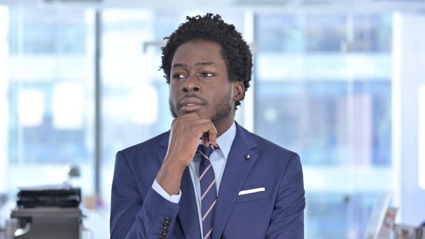 Амбициозный афроамериканский бизнесмен думает в офисе
 - Фото, изображение