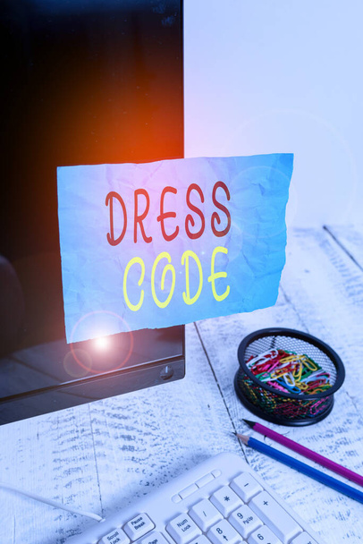 Conceptual hand writing showing Dress Code. Business photo showcasing an accepted way of dressing for a particular occasion or group Note paper taped to black screen near keyboard stationary. - Photo, Image