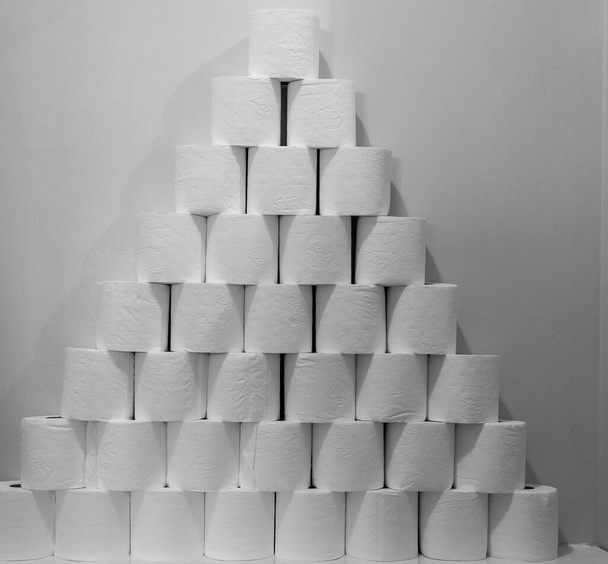Una gran pila de papel higiénico apilado junto a un inodoro
 - Foto, Imagen