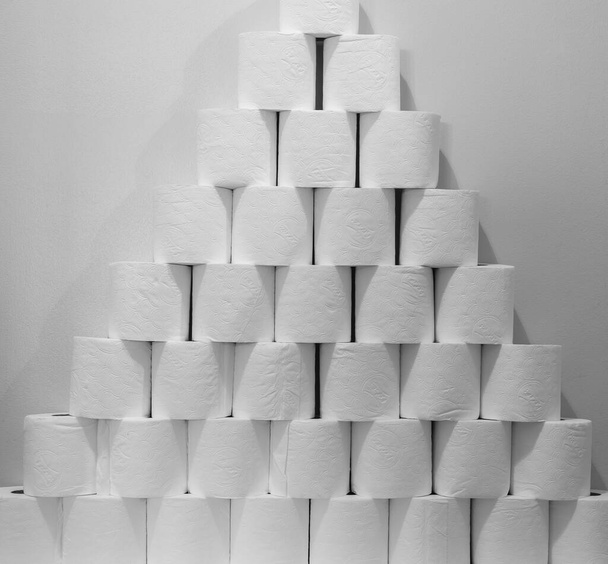 Una gran pila de papel higiénico apilado junto a un inodoro
 - Foto, imagen
