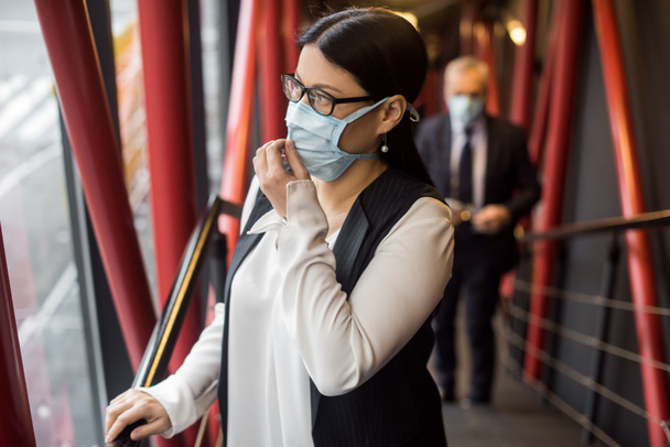 asian businesswoman in formal wear with medical mask looking away  - Foto, afbeelding
