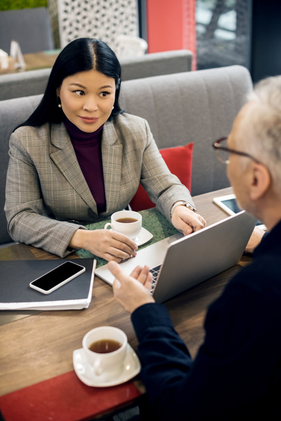 избирательный фокус азиатской предпринимательницы, беседующей с бизнесменом в кафе
  - Фото, изображение