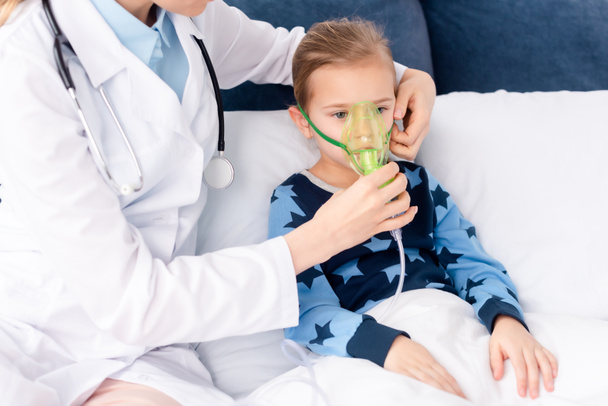 doctor touching respiratory mask on asthmatic kid  - Photo, Image