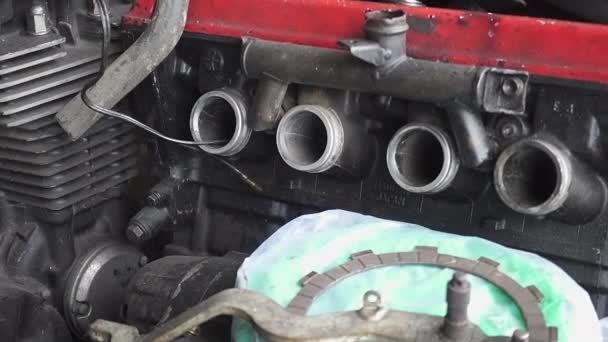 Egy régi, használhatatlan motor része, ami egy régi koszos garázsban tárolódik. Lassú műszak fókusz kézi lassított felvétel, 29,97 fps. - Felvétel, videó