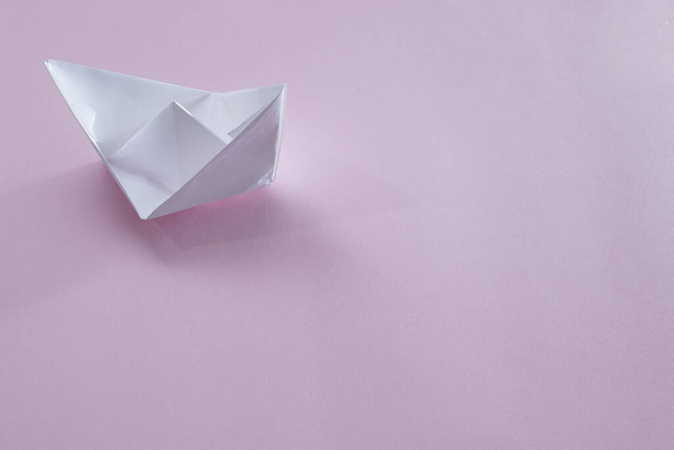 White paper handmade origami boat on the pink background. Copy space for your text. Theme of homemade toys for children. - Foto, immagini