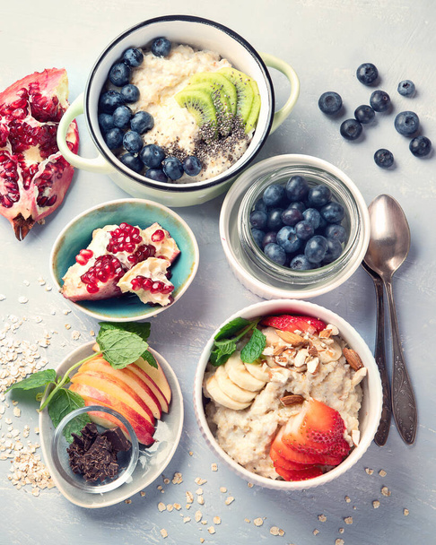 Bowls of oatmeal with berries and fruits  for healthy breakfast. Food with vitamins, minerals and antioxidants. Top view  - Foto, afbeelding