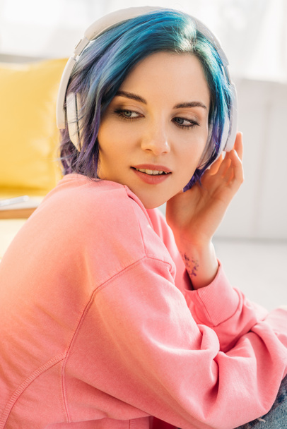 Gyönyörű nő színes hajjal és fejhallgatóval zenét hallgat és elnéz - Fotó, kép