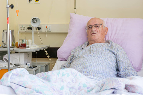 Homem idoso deitado em uma cama no hospital
. - Foto, Imagem