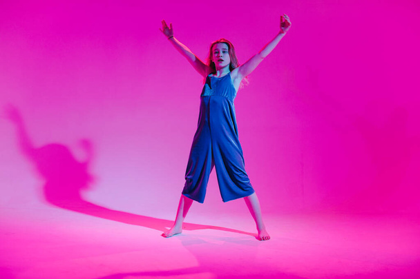 Joven chica elegante bailando en el estudio sobre un fondo de neón de color. Diseño de póster de música dj
. - Foto, imagen