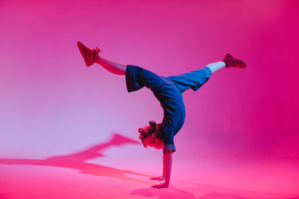 Fiatal elegáns lány táncol a stúdióban egy színes neon háttér. Zene dj poszter design. - Fotó, kép