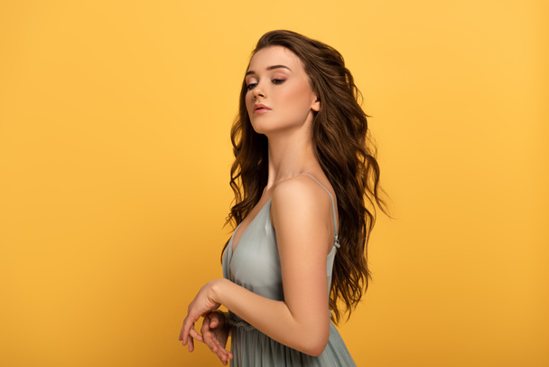 beautiful spring girl with long hair in dress isolated on yellow - Foto, Imagem