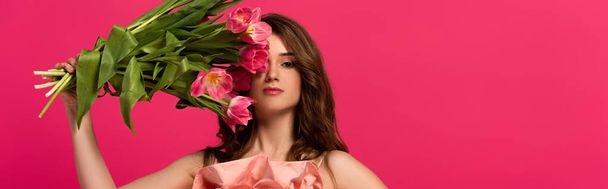 panoramic shot of girl holding bouquet of spring tulip flowers isolated on pink - Foto, Imagen