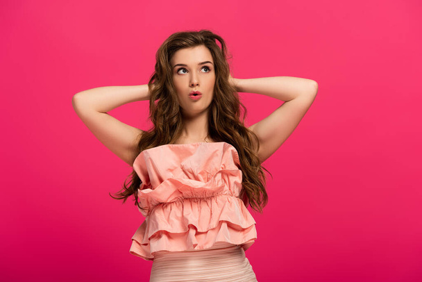 surprised beautiful girl standing in elegant dress isolated on pink  - Foto, immagini