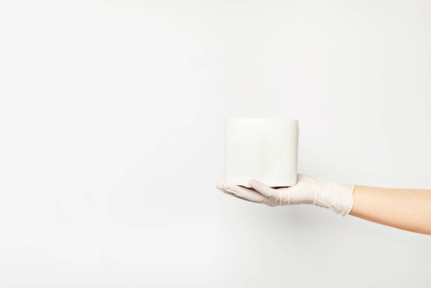 Toilet paper lying on a womans hand wearing a glove. - Φωτογραφία, εικόνα