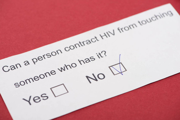  paper card with HIV questionnaire on red background - Photo, Image