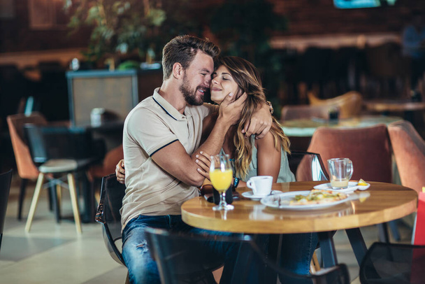 Joven pareja feliz comiendo pizza en un restaurante
 - Foto, Imagen