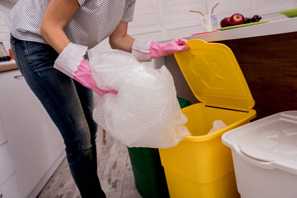 Young girl sorting garbage at the kitchen. Concept of recycling. Zero waste - Фото, изображение