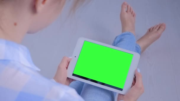 Женщина смотрит на планшетный компьютер с чистым зеленым экраном - концепция хрома ключ - Кадры, видео