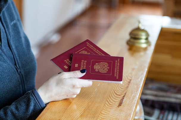 Naiskädellä on Venäjän passi puisessa vastaanotossa
 - Valokuva, kuva
