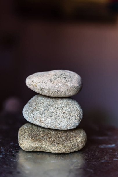 Pila de tres piedras de guijarro sobre fondo oscuro
 - Foto, Imagen